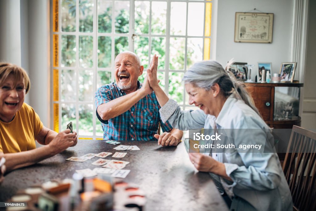 Group of people, senior people playing cards in nursing home.